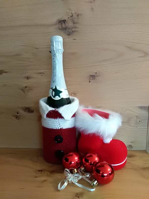 Sektflasche mit gehäkelter Weihnachtsmann-Flaschenhülle, roter Stiefel und rote Kugeln