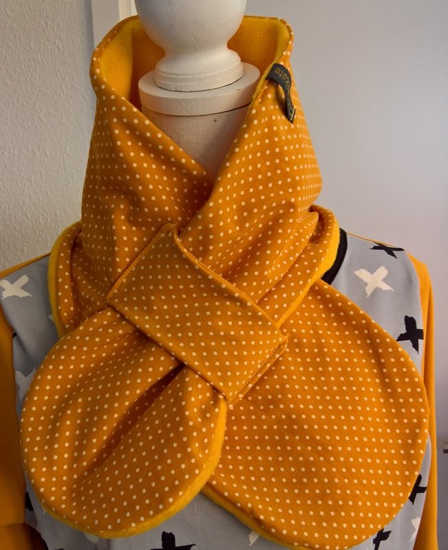 Gekreuzter Schal gelb mit weißen Punkten auf Schneiderpuppe