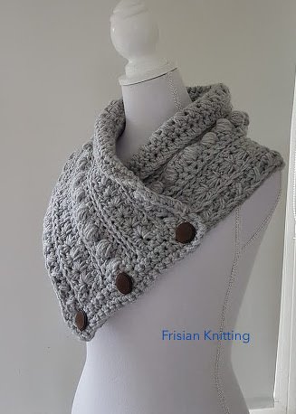 Light grey chunky crocheted collar scarf with three dark buttons displayed on a dress form