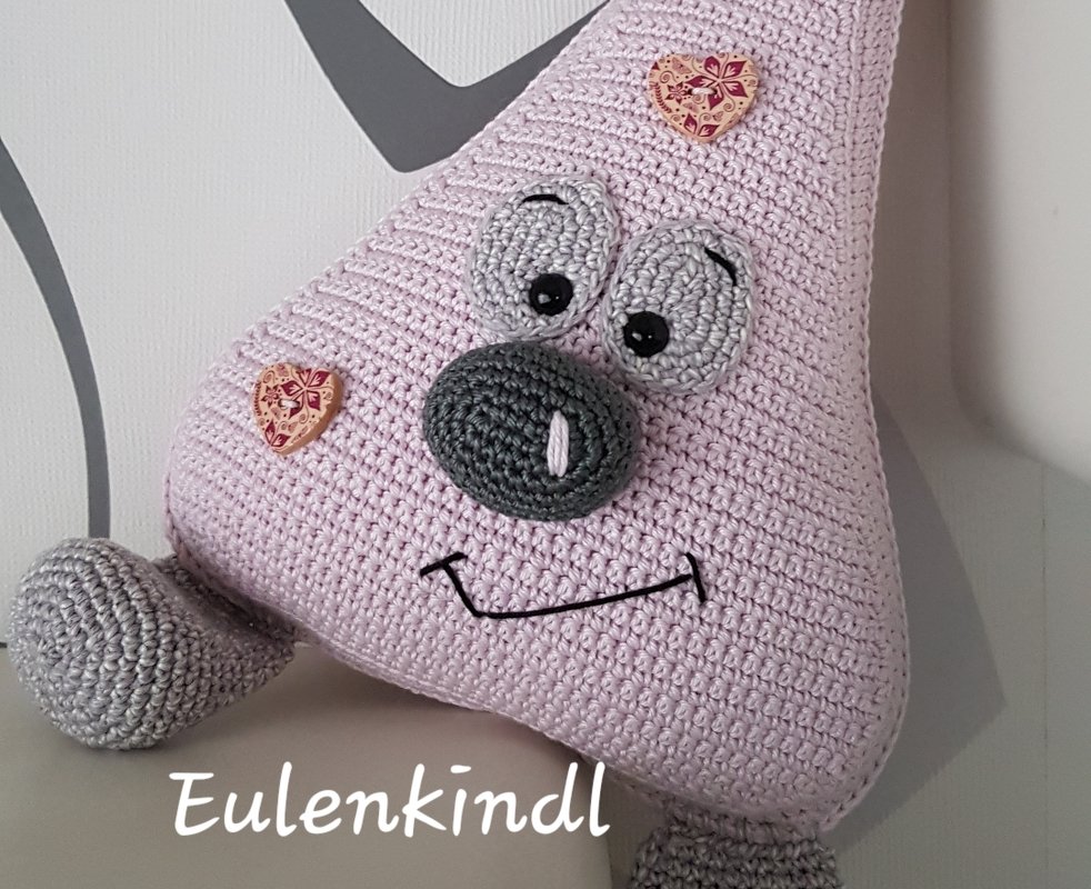 Rosa gehäkelter Amigurumi-Türstopper mit Augen, grauer Nase und Herzknöpfen