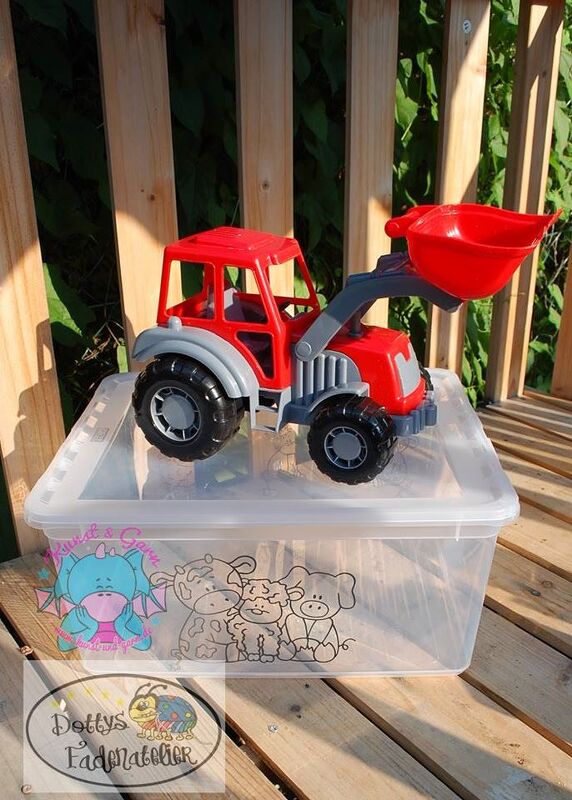 Roter Spielzeugtraktor auf transparenter Kunststoffbox mit Umrissmotiven von Kuh, Schaf, Schwein und einem Drachen.