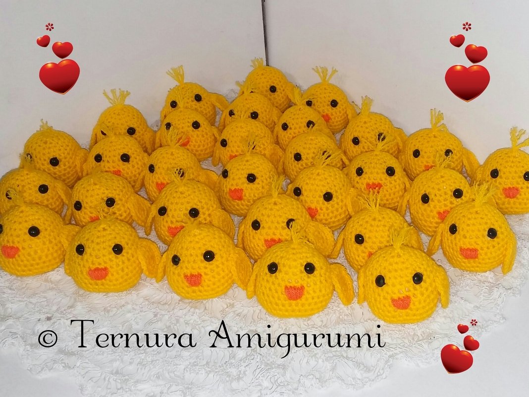 Mehrere gehäkelte gelbe Amigurumi-Küken mit schwarzen Augen und orangen Schnäbeln