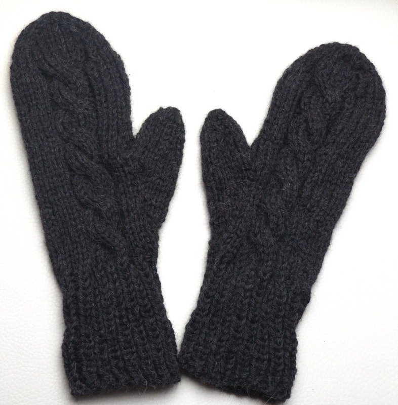 Zwei dunkelgraue Strickfäustlinge mit Zopfmuster und Rippenbündchen