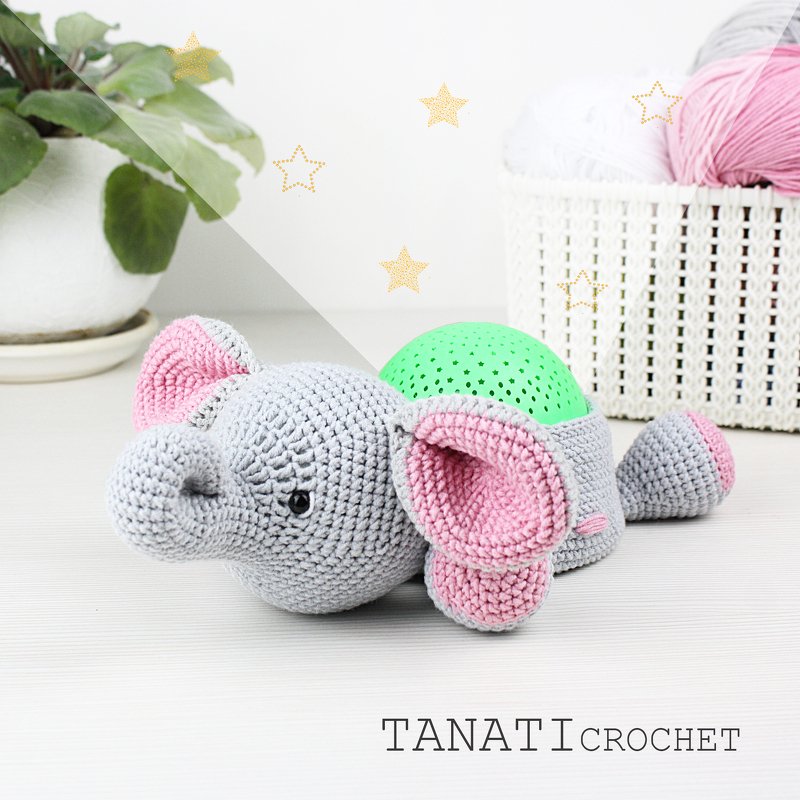 Gehäkelter grauer Amigurumi-Elefant mit rosa Innenohren und grünem, sternförmig perforiertem Rückenelement