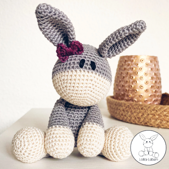 Gehäkeltes graues und cremefarbenes Esel-Amigurumi mit Schleife am Ohr