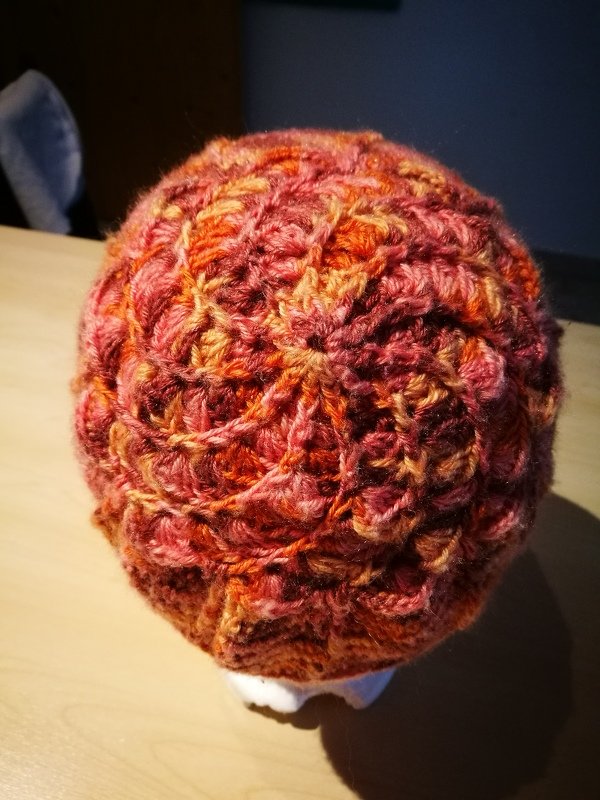 Gehäkelte Damenmütze in Rot-Orange mit Muschelmuster, von oben gezeigt