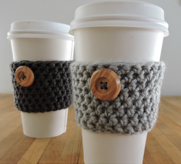 Disposable coffee cups with fast-to-crochet grey sleeves secured by wooden buttons