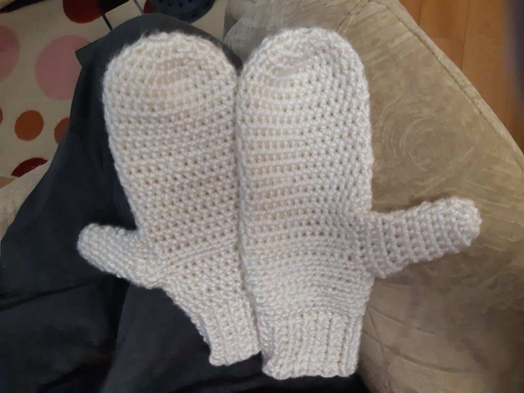Close-up of crocheted women's mitten showing ribbed cuff, thumb placement and stitch texture