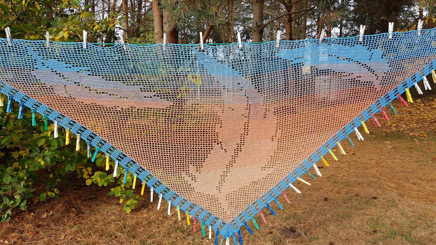 Gehäkeltes Dreieckstuch in Blau, Türkis und Orange mit Blattmuster an Wäscheleine