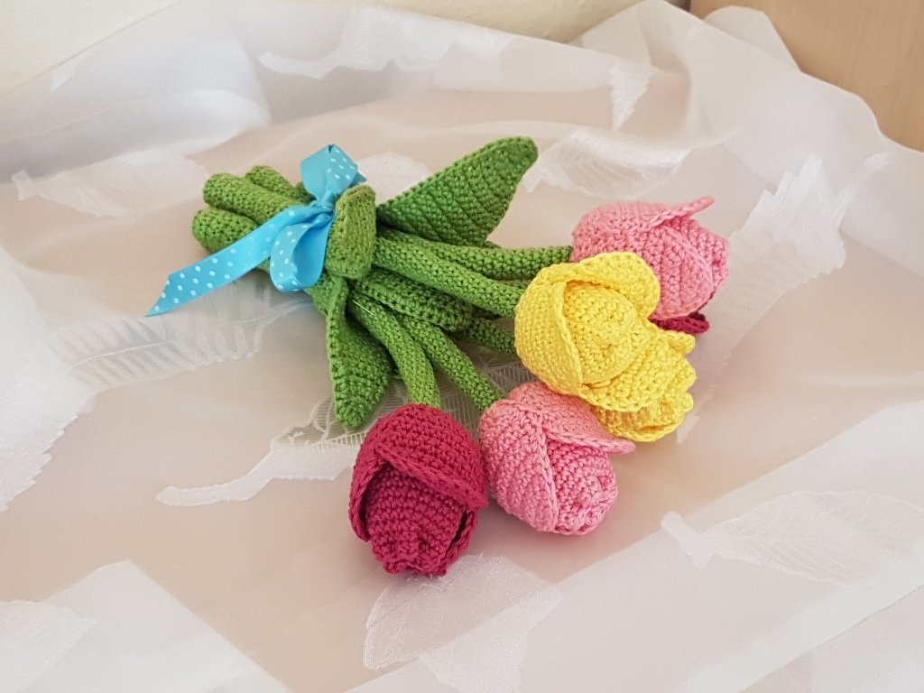 Gehäkelter Tulpenstrauß in Gelb, Rosa und Dunkelrosa mit grünen Stielen und blauem Band