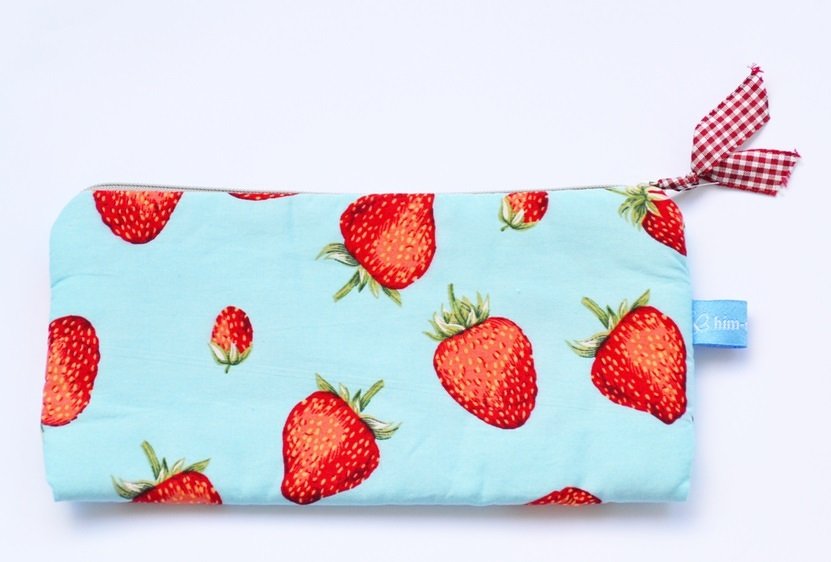 Hellblaue Stofftasche mit roten Erdbeeren und Reißverschluss.