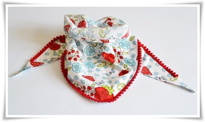 Dreieckshalstuch für Kinder mit hellem Blumenprint und roter Pomponborte