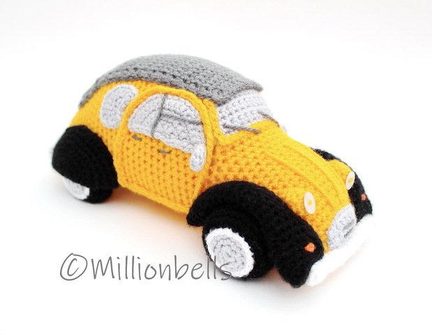Yellow crocheted amigurumi car with grey roof and black wheels