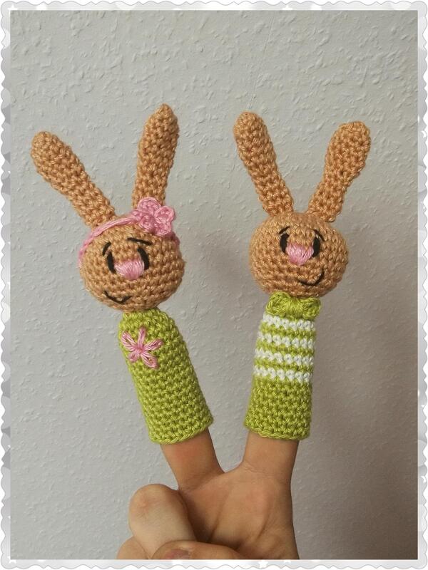 Zwei gehäkelte Hasen-Fingerpuppen mit langen Ohren, grün-beigen Körpern und rosa Details