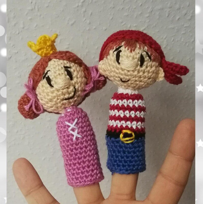 Zwei gehäkelte Fingerpuppen: Prinzessin mit Krone und Seemann mit gestreiftem Oberteil auf zwei Fingern.