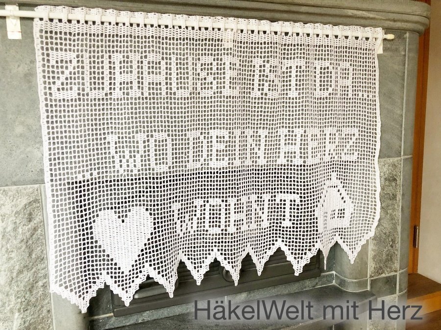 Weiße Filet-Häkelgardine mit Spruch 'Zuhause ist wo dein Herz ist', Herzmotiven und gezacktem Saum