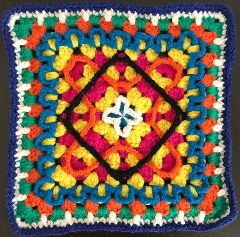 Quadratische Häkelapplikation (Granny-Square) in lebhaften Farben mit dunkelblauem Rand