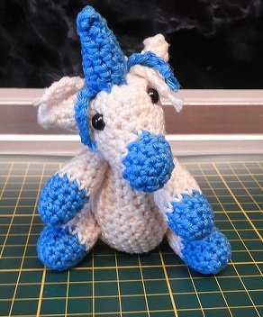 Gehäkeltes blau-weißes Amigurumi-Einhorn mit Horn und schwarzen Augen