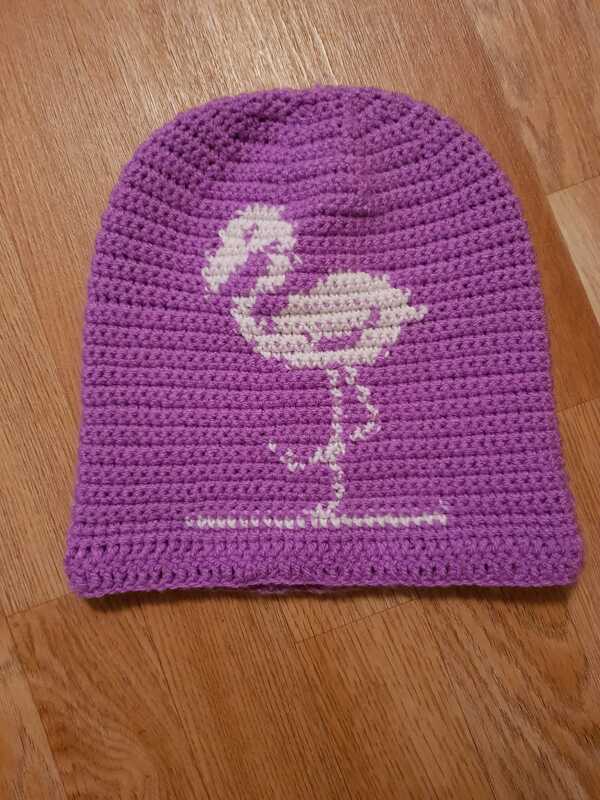 Lila gehäkelte Mütze mit weißem Flamingo