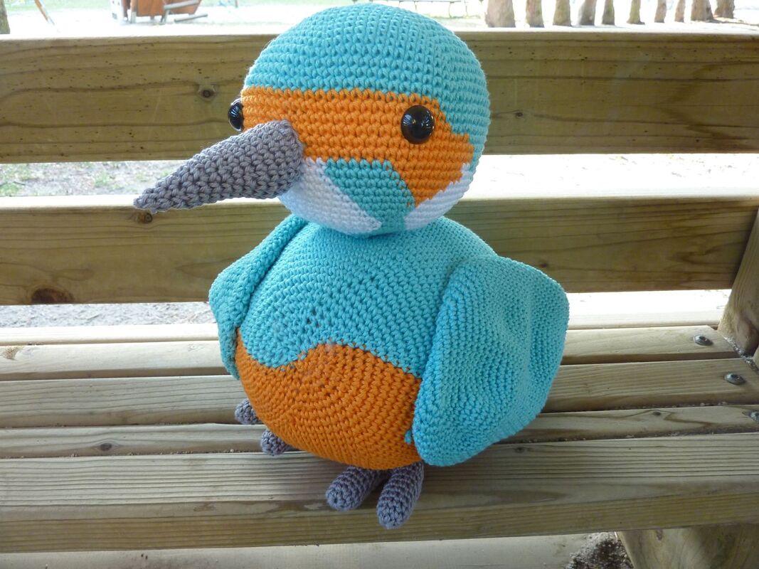 Gehäkelter Amigurumi-Vogel türkis-orange mit grauem Schnabel und schwarzen Augen