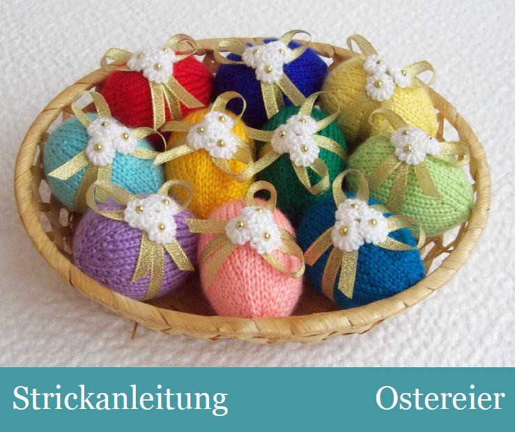 Korb mit bunten, handgestrickten Ostereiern, verziert mit weißen Blüten und goldfarbenen Schleifen