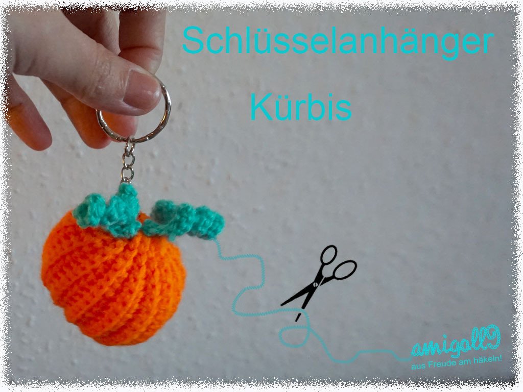 Hand holding an orange crocheted pumpkin keychain with green leaves and a metal ring.