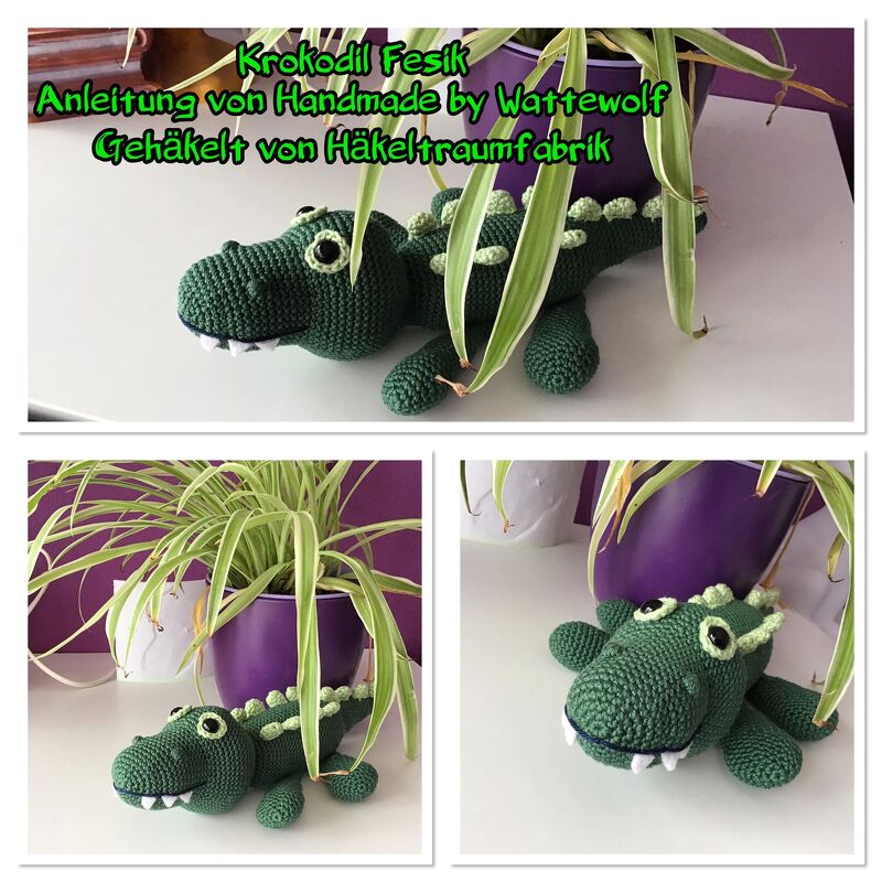 Grünes gehäkeltes Amigurumi-Krokodil mit hellgrünen Noppen liegt vor einer Topfpflanze