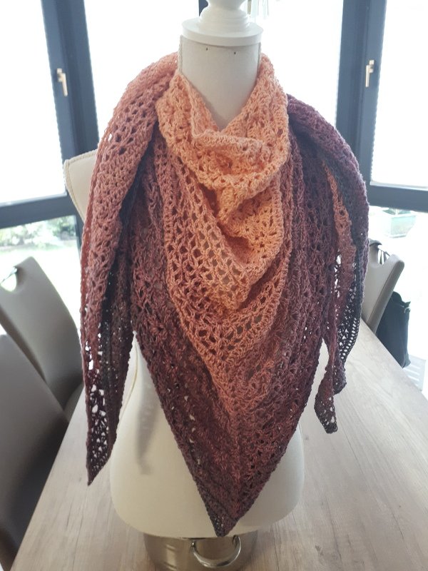 Gehäkeltes Dreieckstuch mit offenem Spitzenmuster in Pfirsich- bis Brauntönen auf Schneiderpuppe