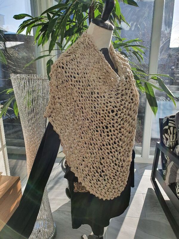 Schaufensterpuppe trägt beigen großmaschigen gestrickten Dreieckponcho
