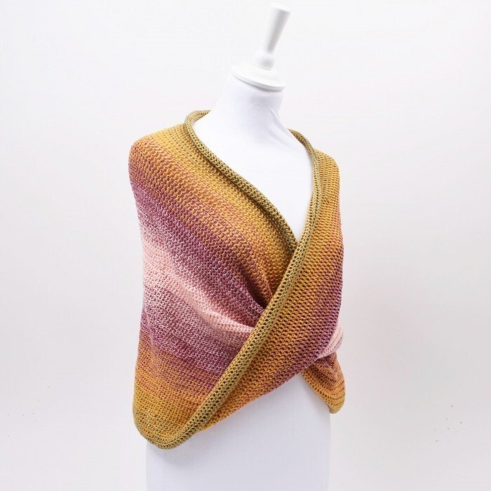 Mannequin wearing a gradient crochet wrap in mustard, rose and mauve with olive edge