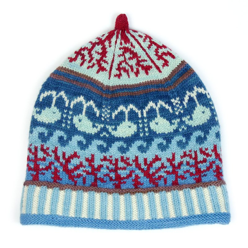 Knitted hat with blue whale and wave motifs, red coral patterns, and a striped brim.