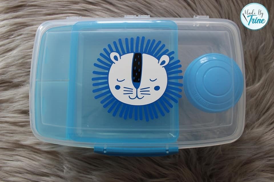 Transparente Brotdose mit blau-weißem Löwen-Plott auf dem Deckel