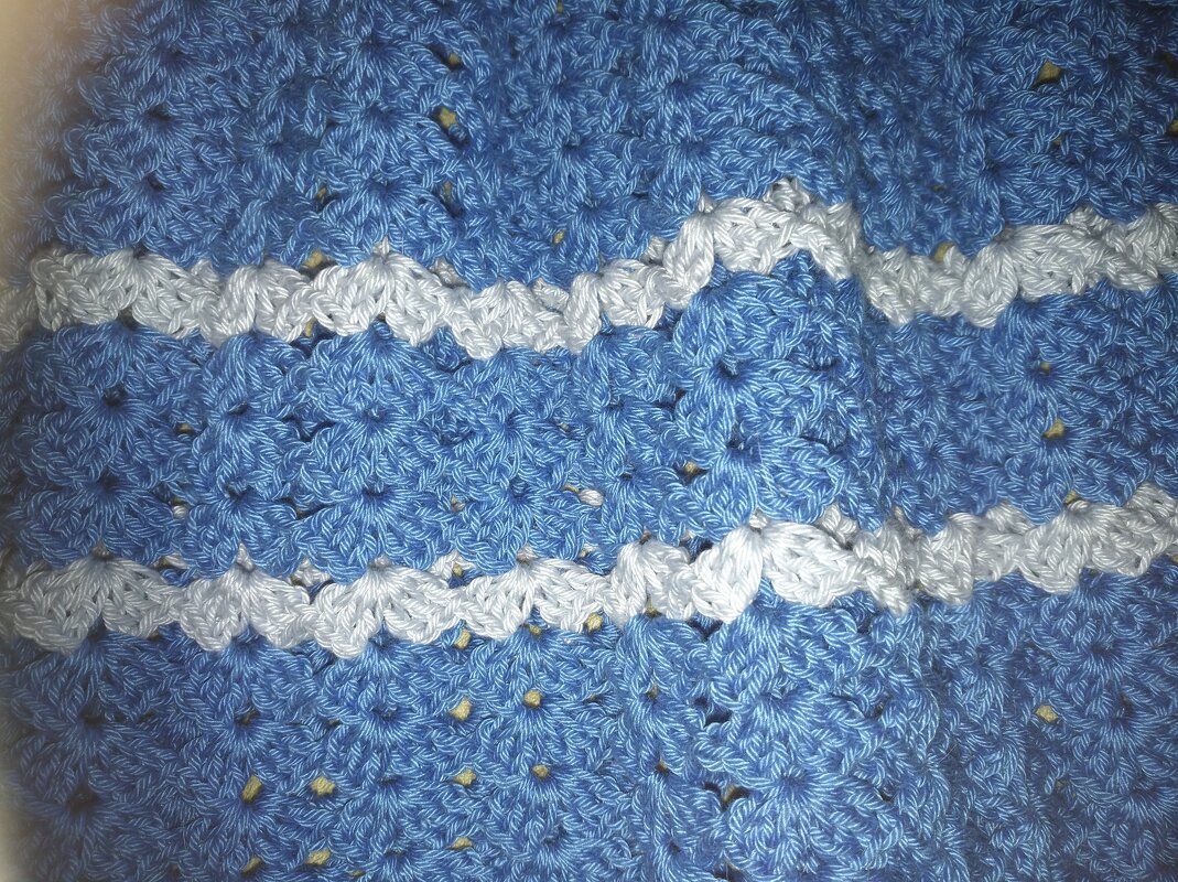 Nahaufnahme gehäkeltes blau-weißes Muschelmuster, Babydecke oder -kleidungsstück