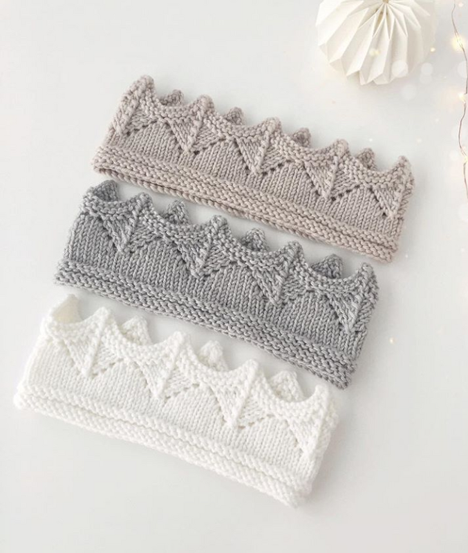 Drei gestrickte Stirnbänder mit Kronenmuster in Beige, Grau und Weiß auf hellem Hintergrund