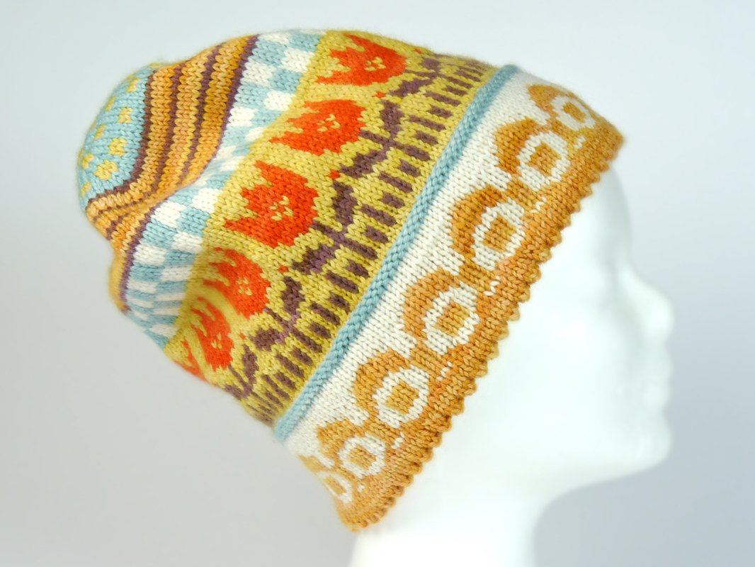 Knitted slouchy beanie with colorful Fair Isle patterns on a white mannequin head