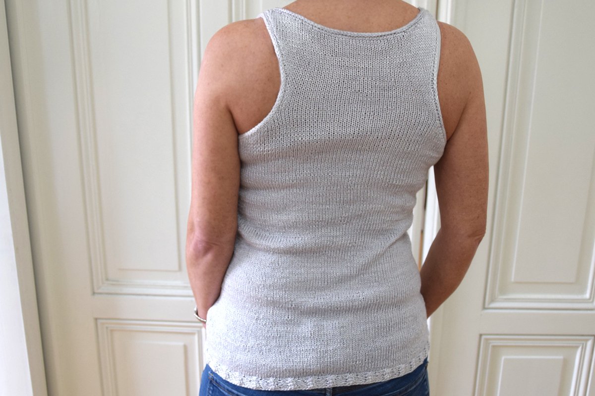 Rückenansicht eines hellgrauen, glatt rechts gestrickten ärmellosen Tops mit feiner Saumbordüre