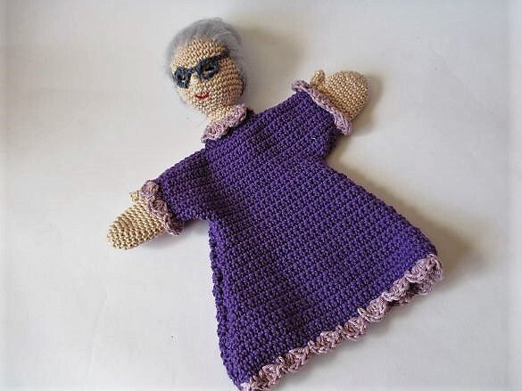 Gehäkelte Handpuppe Großmutter mit grauem Haar, schwarzer Sonnenbrille und lila Rüschenkleid
