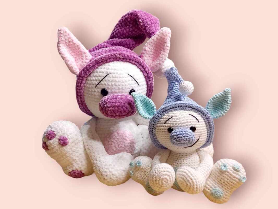 Zwei gehäkelte Amigurumi-Häschen in Pastellfarben mit Zipfelmützen
