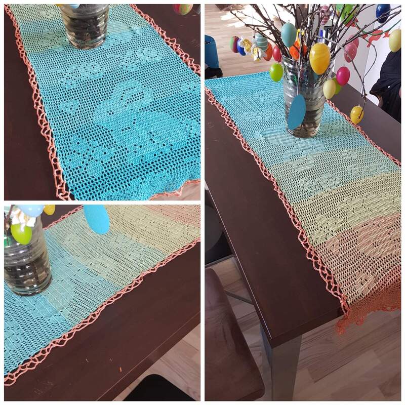 Handgehäkelter Tischläufer in Pastell (Türkis, Grün, Gelb, Orange) auf dunklem Tisch neben Vase mit Osterzweig und bunten Eiern