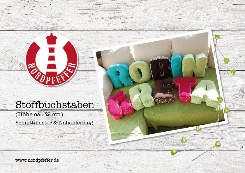 Gefüllte, bunte Stoffbuchstaben auf grünem Sofa