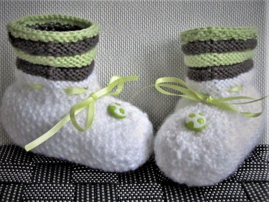 weiße gestrickte Babyschuhe mit grün-grau gestreiftem Bündchen und hellgrünem Satinband
