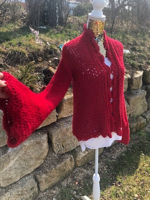 Rote offene Häkeljacke mit Trompetenärmeln und gezacktem Saum an Puppe