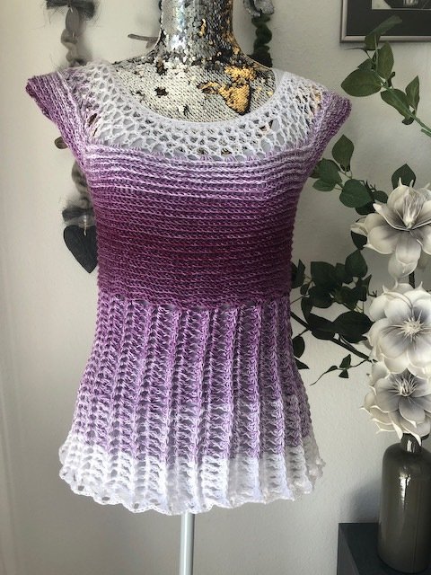 Ombre Häkel‑Tunika in Lila und Weiß mit Ajourkragen auf einer Puppe