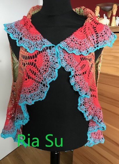 Ärmellose gehäkelte Damenweste in Koralle und Türkis mit Rüschenkante auf Schneiderbüste