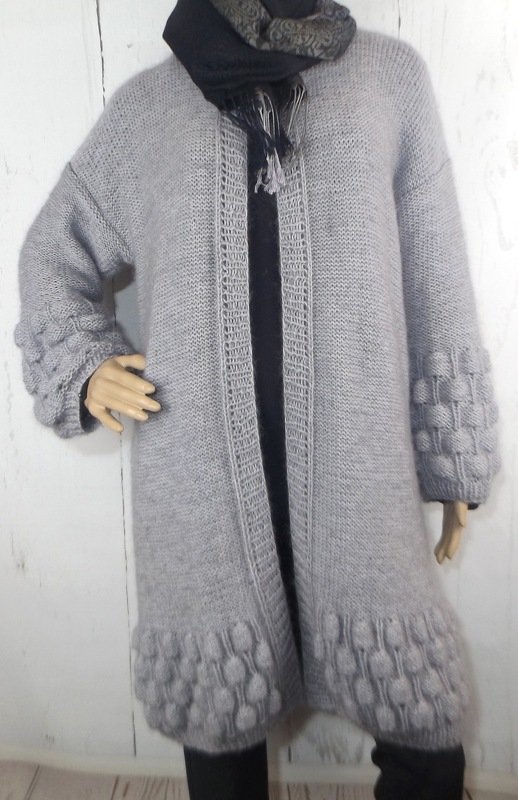 Grau gestrickte lange Damenjacke mit strukturierter Borte an Saum und Ärmeln an einer Schaufensterpuppe