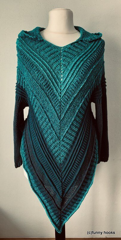 Hooded teal crochet poncho sweater with V-shaped ribbed panels on a mannequin