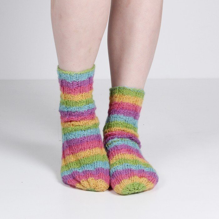 Feet wearing knitted socks with rainbow stripes