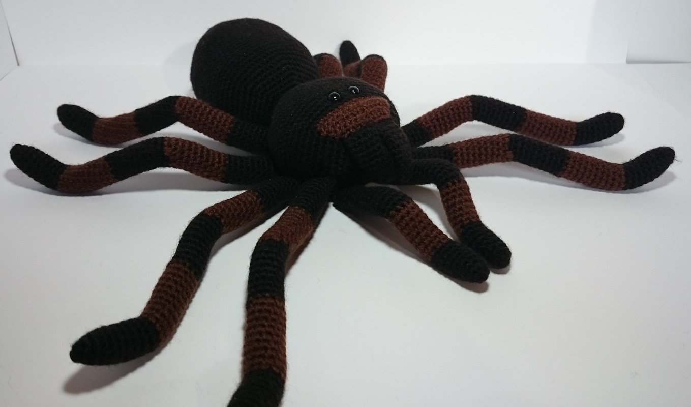 Gehäkelte Spinne mit acht gestreiften Beinen in Schwarz und Braun
