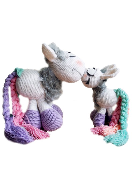 Zwei pastellfarbene Pony-Amigurumi mit geflochtenen Zöpfen und violetten Hufen