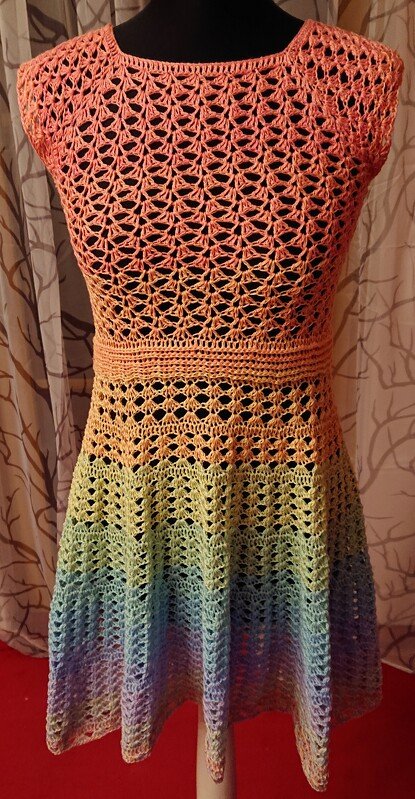 Ärmelloses gehäkeltes Kleid mit A‑Linie und Regenbogen‑Farbverlauf auf einer Schneiderpuppe